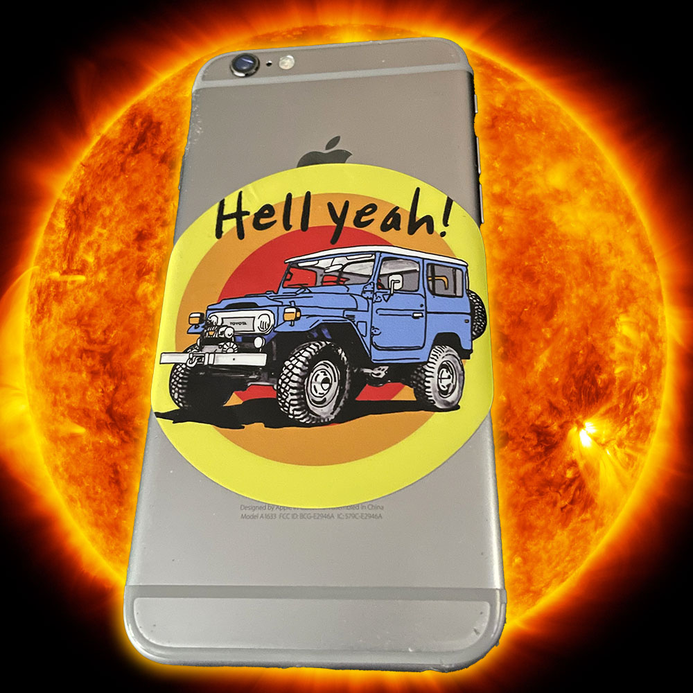 Hell Yeah FJ40 sticker on the back of an iPhone as it sails into a fiery sun